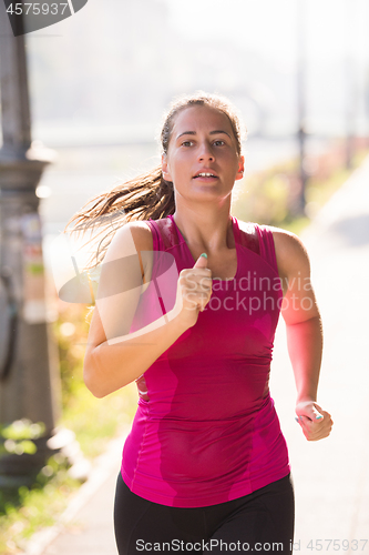 Image of woman jogging at sunny morning