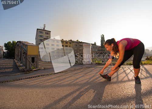 Image of athlete woman warming up and stretching