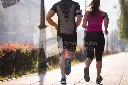 Image of young couple jogging  in the city