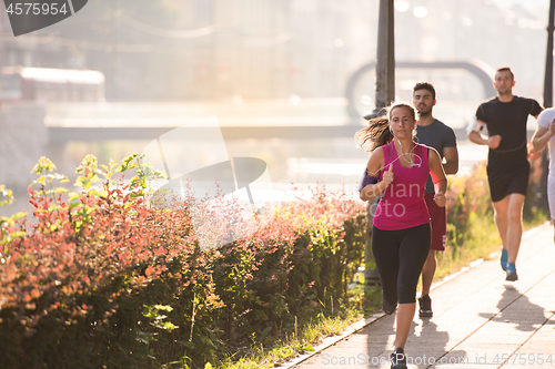 Image of group of young people jogging in the city