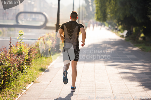 Image of man jogging at sunny morning