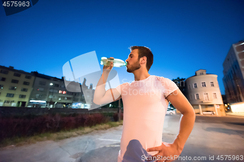 Image of man drinking water after running session