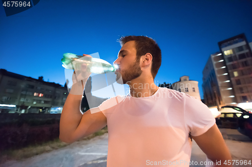 Image of man drinking water after running session