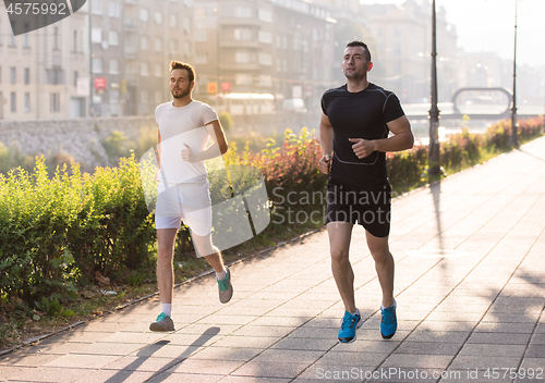 Image of group of young people jogging in the city