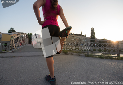 Image of athlete woman warming up and stretching