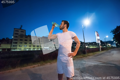 Image of man drinking water after running session