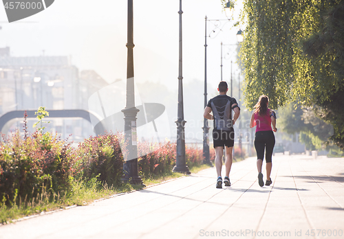 Image of young couple jogging  in the city