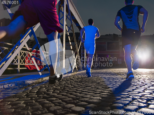 Image of young people jogging across the bridge