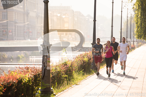 Image of group of young people jogging in the city