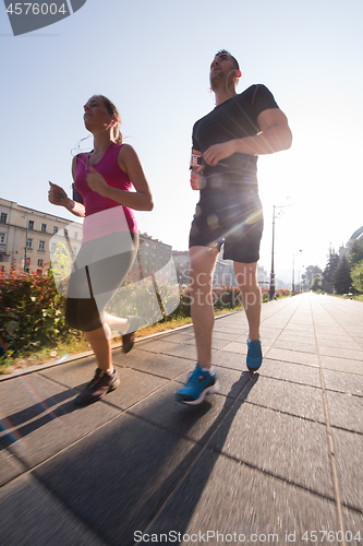 Image of young couple jogging  in the city