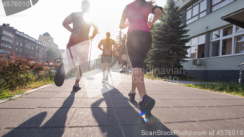 Image of group of young people jogging in the city