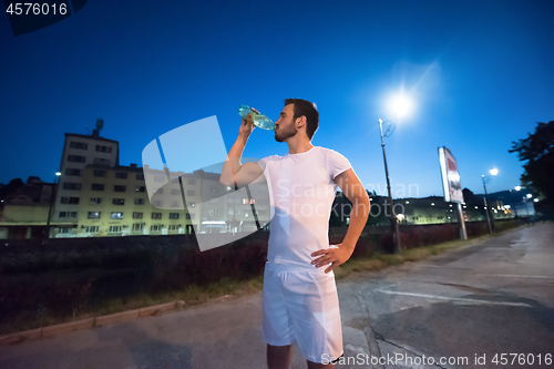 Image of man drinking water after running session