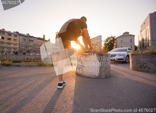 Image of man tying running shoes laces