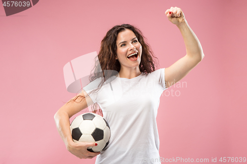 Image of Fan sport woman player holding soccer ball isolated on pink background