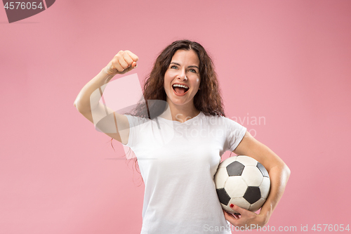 Image of Fan sport woman player holding soccer ball isolated on pink background