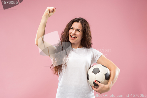 Image of Fan sport woman player holding soccer ball isolated on pink background