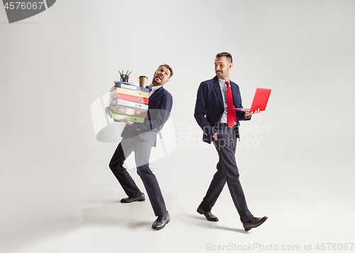 Image of Young businessman in a suit juggling with office supplies in his office, isolated on white background