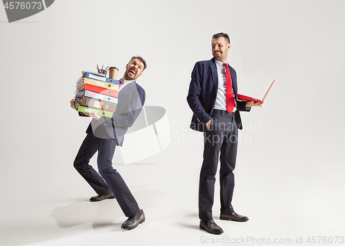 Image of Young businessman in a suit juggling with office supplies in his office, isolated on white background