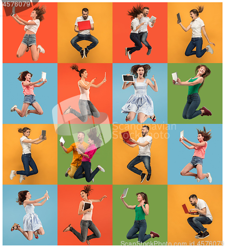 Image of Image of young women and man over colorful background using laptop computer or tablet gadget while jumping.
