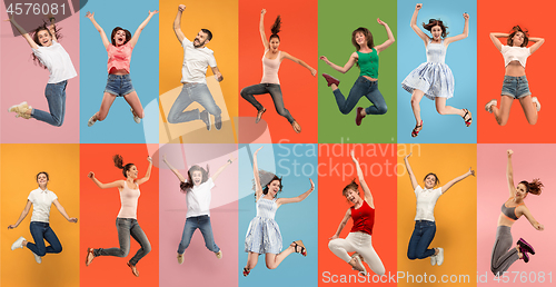 Image of Freedom in moving. Pretty young woman jumping against orange background