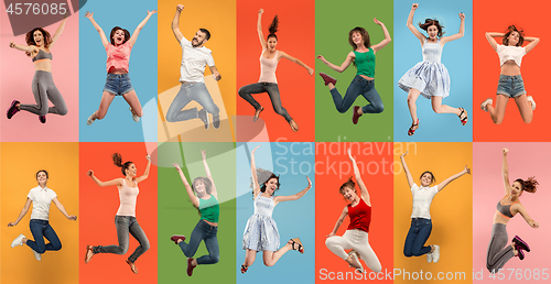 Image of Freedom in moving. Pretty young woman jumping against orange background