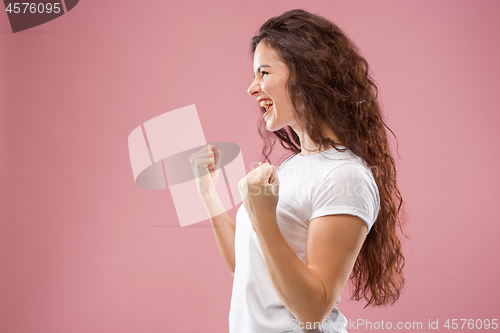 Image of The happy business woman standing and smiling against pink background.
