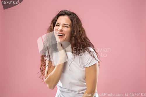 Image of The happy business woman standing and smiling against pink background.