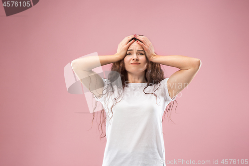 Image of Woman having headache. Isolated over pink background.