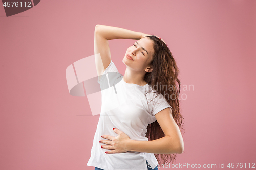 Image of The happy business woman standing and smiling against pink background.