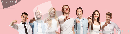 Image of The happy business women and men point you and want you, half length closeup portrait on pink background.