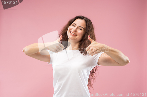 Image of The happy business woman standing and smiling against pink background.