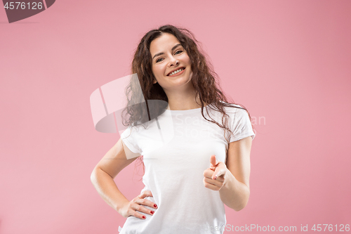 Image of The happy business woman standing and smiling against pink background.