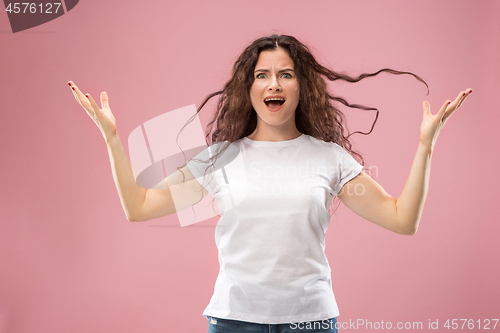 Image of Portrait of an angry woman looking at camera isolated on a pink background