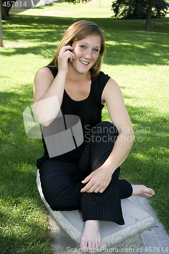 Image of Beautiful Girl in the Park in a Black Dress Talking on the Phone