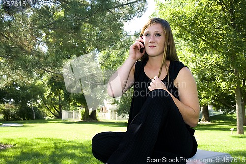 Image of Beautiful Girl in the Park in a Black Dress Talking on the Phone