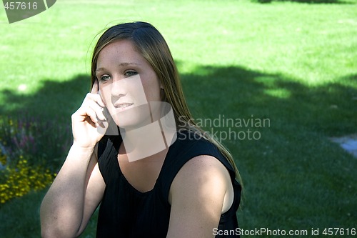 Image of Beautiful Girl in the Park in a Black Dress Talking on the Phone