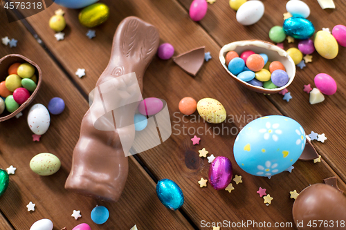 Image of chocolate eggs, easter bunny and candies on wood