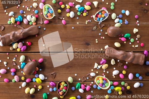 Image of chocolate eggs, easter bunnies and candies on wood