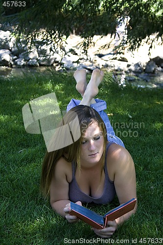 Image of Beautiful Girl in the Park Reading a Book