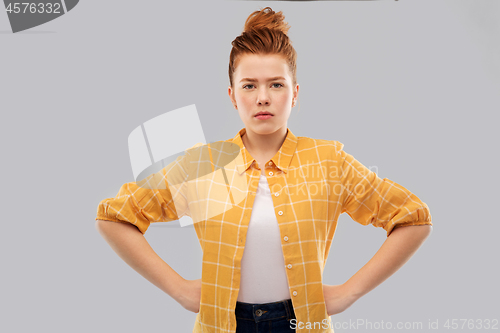 Image of serious red haired teenage girl with hands on hips