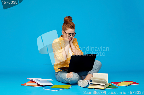 Image of stressed student girl with laptop and books