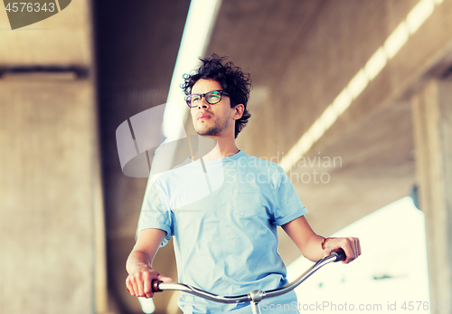 Image of young hipster man riding fixed gear bike