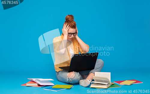 Image of stressed student girl with laptop and books