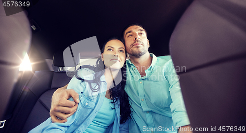 Image of happy man and woman hugging on taxi back seat