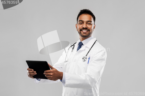 Image of smiling indian male doctor with tablet computer