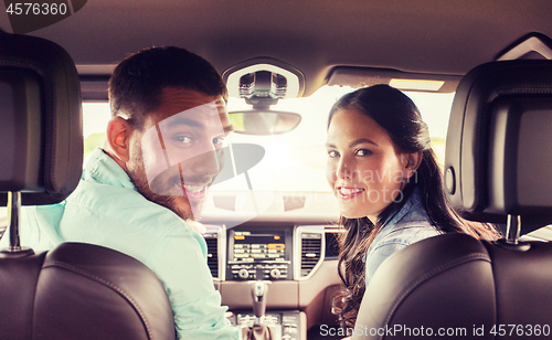 Image of happy man and woman driving in car