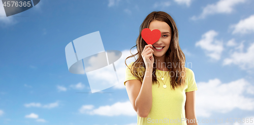 Image of smiling teenage girl covering her eye by red heart