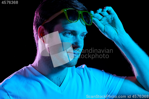 Image of man in sunglasses over ultra violet neon lights