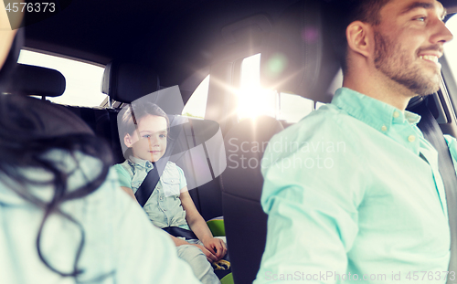 Image of happy family with little child driving in car