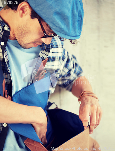 Image of close up of hipster man looking into his bag